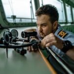 Focused sailor using a sextant for navigation aboard a ship. Maritime expertise in action.